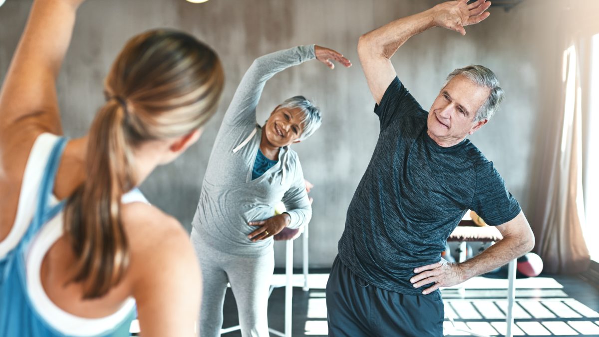 Shot of a senior man and woman working out with the help of an instructor.